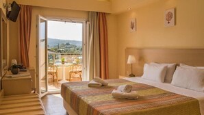 Una habitación de hotel con cama, escritorio, silla y balcón con vistas.