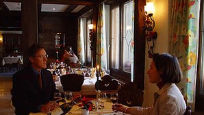 Un restaurante con mesas dispuestas para comer, un camarero y un cliente.