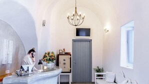 Ein modernes Interieur mit einer Rezeption, einem weißen Sofa und einer Kristallleuchter.