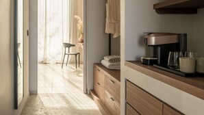 Une cuisine moderne équipée d’une machine à café, d’un meuble en bois et d’une vitrine.