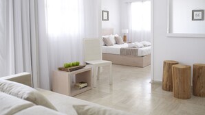 Un dormitorio moderno y minimalista con cama, mesita de noche y una silla.