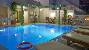 Una piscina con sillas de descanso y una zona de bar.
