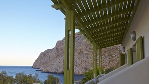 Un espacio al aire libre techado con vista al mar y un acantilado rocoso.