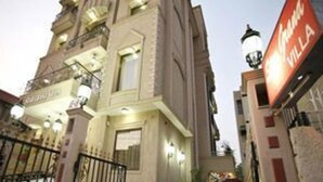 A multi-story hotel with a prominent sign reading "Grand Villa." - Star Grand Villa (New Delhi)