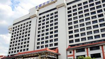 Un gran edificio de hotel con varios pisos y un pabellón de entrada tradicional.