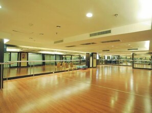 A spacious dance studio with a polished wooden floor, mirrored walls, and a few chairs. - Grand Dynasty Culture (Xi'an)