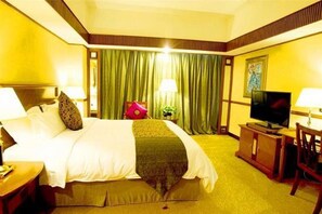 A hotel room with a bed, a television, a desk, and a chair. - Grand Dynasty Culture (Xi'an)