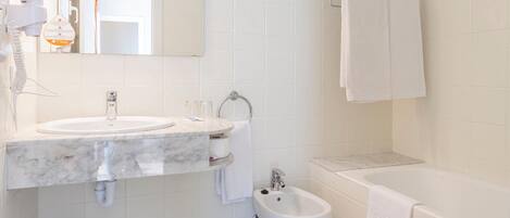 Een moderne badkamer met een wastafel, toilet en bad.
