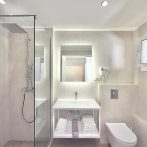 A modern bathroom with a glass-enclosed shower, a white vanity with a mirror, and a toilet.