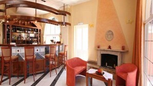 A bar area with wooden chairs and a fireplace. - Philoxenia Hotel (Corfu)