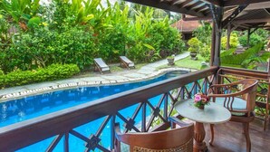 A poolside area with a view of lush greenery, a small pool, and a covered seating area with a table and chairs. - Villa Chempaka (Ubud)