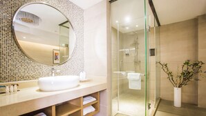 A modern bathroom with a large mirror, a glass-enclosed shower, and a wooden vanity. - Lavande Hotel (Zhanjiang)