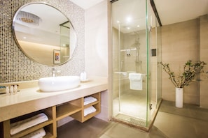 A modern bathroom with a large mirror, a glass-enclosed shower, and a wooden vanity. - Lavande Hotel (Zhanjiang)