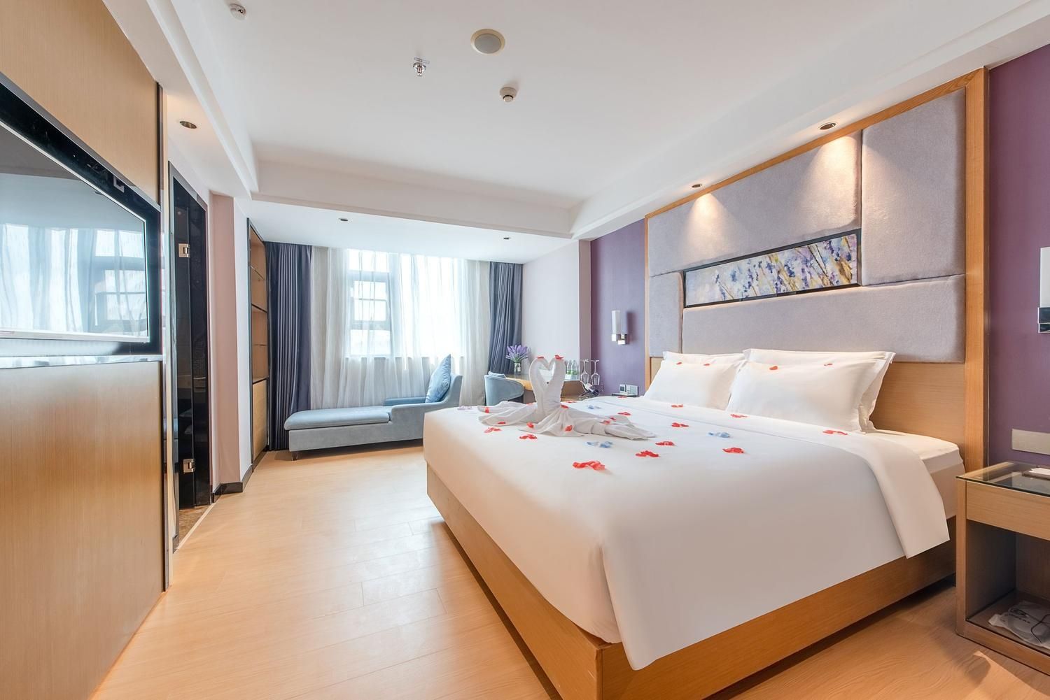 Une chambre d’hôtel avec un grand lit, une table de chevet et une vue sur l’extérieur.