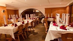A restaurant with multiple tables set for dining, featuring white tablecloths and red napkins. - Albana (Silvaplana)