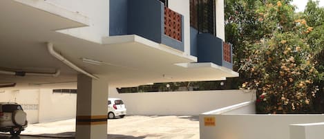 A multi-story building with a parking area in front.