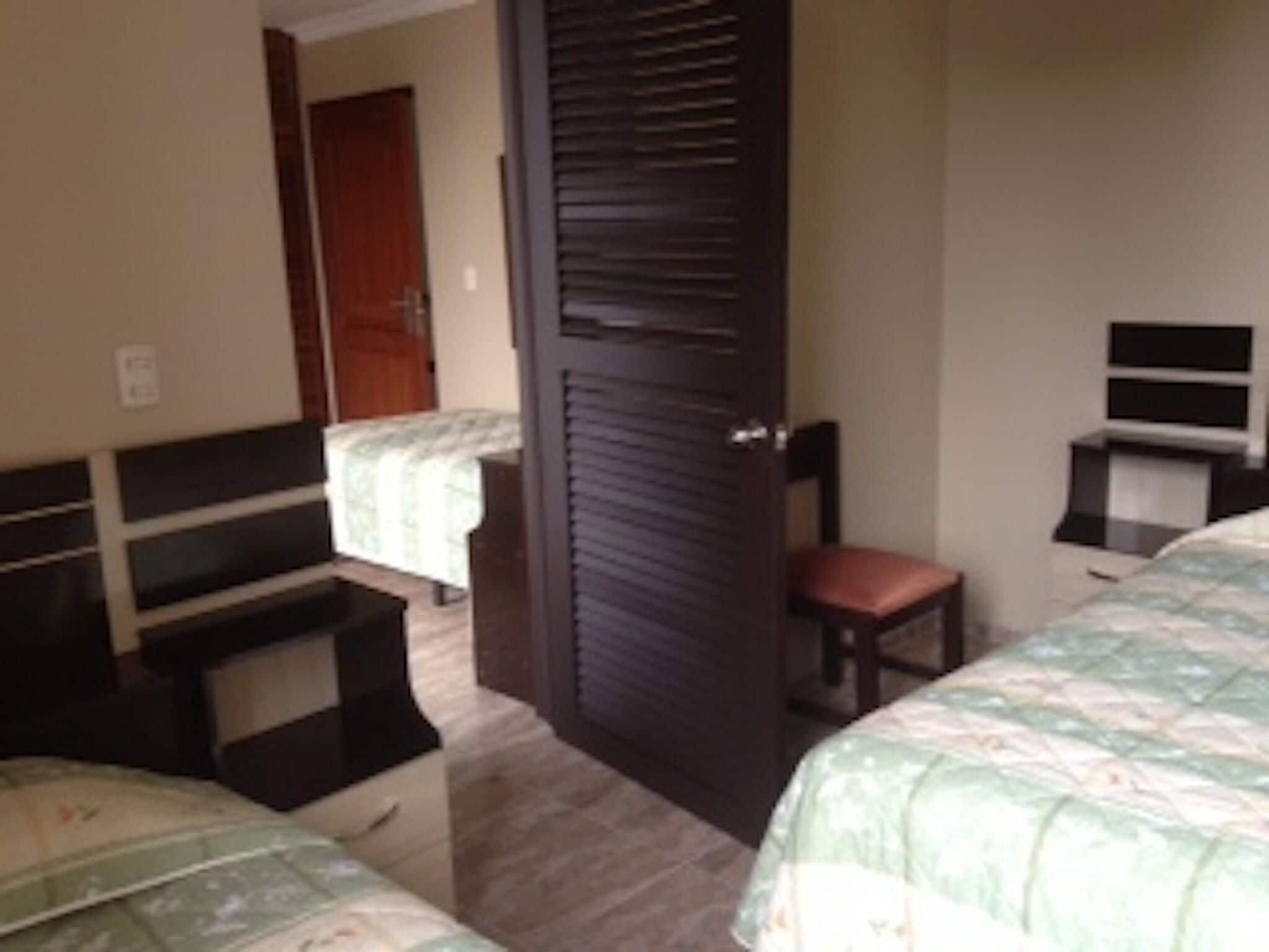 Une chambre à coucher avec un lit, une chaise, un bureau et une armoire.