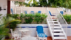 Eine Terrasse mit Sitzgelegenheiten, eine Treppe und Blick ins umgebende Grün.