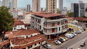 A cityscape with a mix of modern high-rise buildings and older, lower buildings with red-tiled roofs. - Eurohotel Panama (Panama City)
