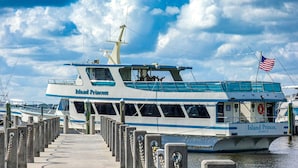 De veerboot 'Island Princess' aanmerkt bij een steiger, met een heldere lucht en rustig water.