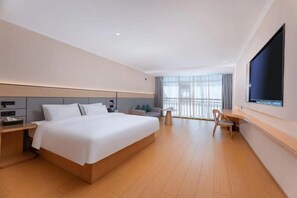 A modern hotel room with a large bed, a desk, a chair, and a TV mounted on the wall. - Greentree Inn (Lianyungang East Jiefang Road) (Lianyungang)