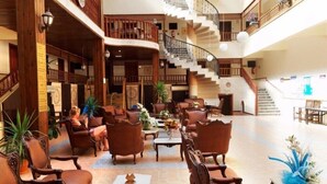 A spacious lobby with a central seating area, a staircase, and multiple balconies. - Ozcan Hotel (Marmaris)