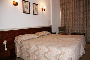 A hotel room with a large bed, a wooden headboard, a bedside telephone, and two wall-mounted lamps. - La Nina (Sant Llorenc des Cardassar)