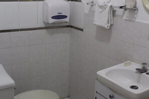 Um banheiro pequeno com vaso sanitário, pia e secador de mãos.