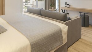 A modern hotel room with a large bed, a sofa, a TV, and a balcony with a view. - Hotel Capricho (Capdepera)
