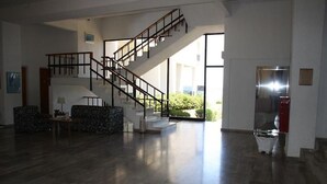 A spacious living area with a staircase, a sofa, and a table. - Lymiatis Beach Hotel (Karpathos)