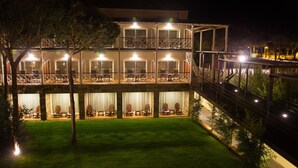 A multi-story hotel with outdoor seating areas and a well-lit balcony. - Nuevo Portil Golf (Cartaya)