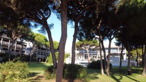 A hotel with a two-story structure, surrounded by trees and a well-maintained lawn. - Nuevo Portil Golf (Cartaya)