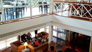 A spacious, multi-level lounge area with a high ceiling and large windows offering views of the outdoors. - Nuevo Portil Golf (Cartaya)