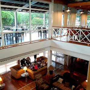 A multi-level indoor space with a dining area on the upper level and a lounge area on the lower level. - Nuevo Portil Golf (Cartaya)