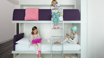 A bunk bed with three children, one on the top bunk and two on the bottom.