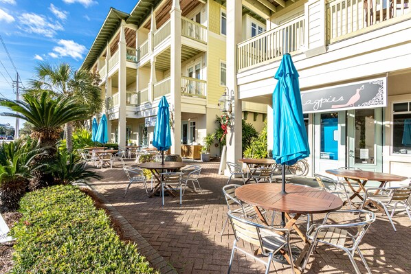 A hotel with outdoor seating, multiple balconies, and a restaurant named "Cagpies". - Private Beach Acces 3Br Top Floor Corner, Ocean View (Sleeps8) (Santa Rosa Beach)