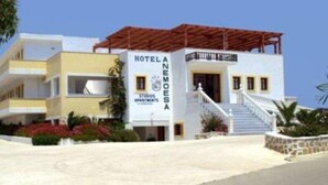 A two-story hotel with a white facade and a red roof. - Anemoessa (Karpathos)