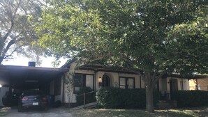 A house with a garage, a tree in front, and a gravel driveway. - Fully furnished duplex in quiet neighborhood (Sweetwater)