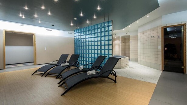 A modern waiting area with lounge chairs, a blue partition, and a sauna entrance. - Saarema Thalasso Spa Hotel (Mandjala)