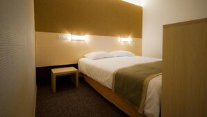 A hotel room with a bed, bedside table, and wall-mounted light fixtures. - Saarema Thalasso Spa Hotel (Mandjala)