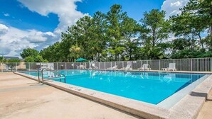 Piscina rectangular con una escalera metálica y una cerca blanca alrededor.