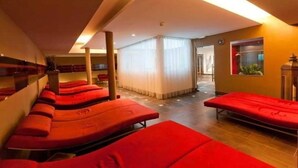Une pièce comprenant plusieurs lits de massage rouges, disposés en rangée.