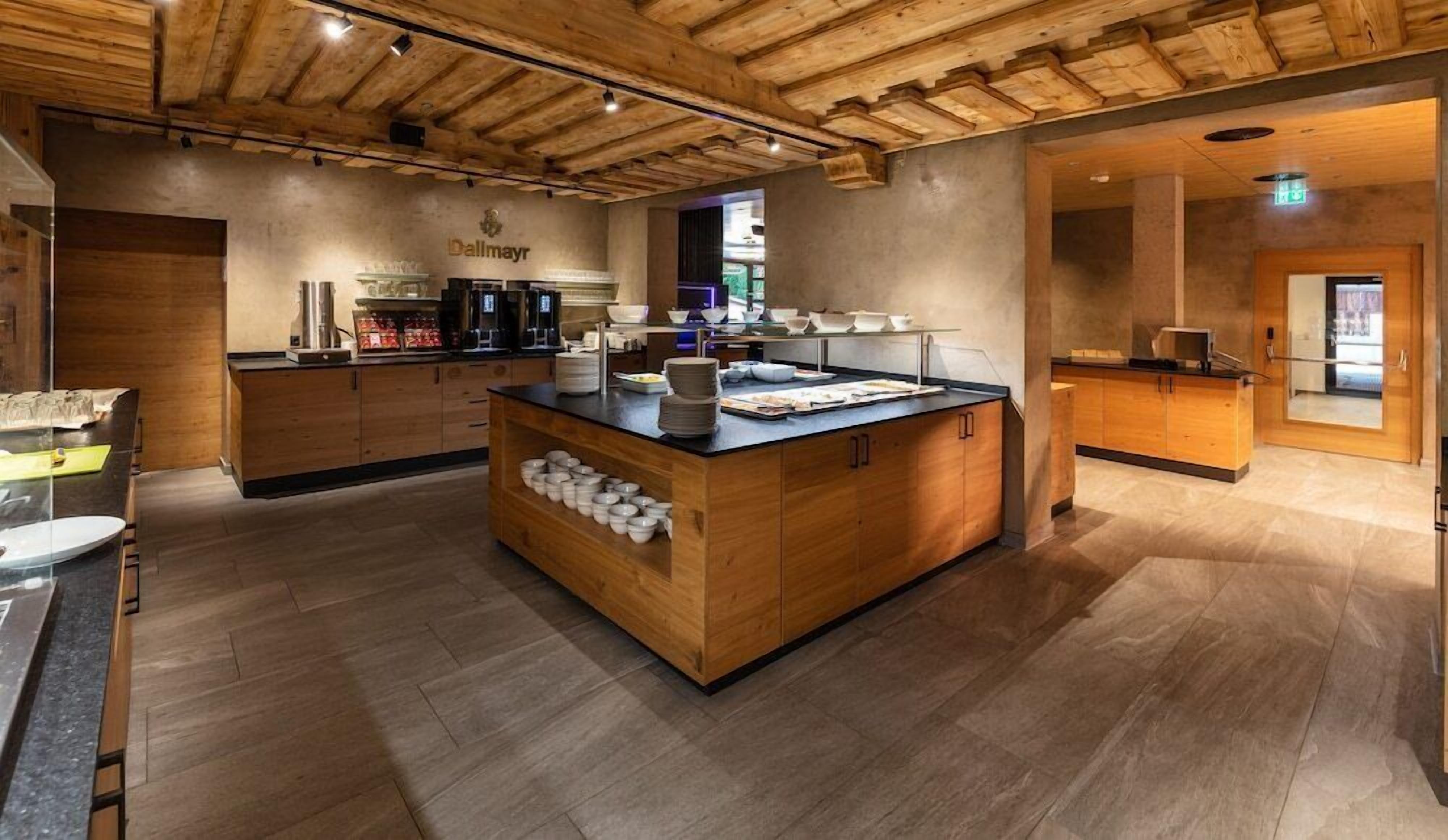 Una cocina moderna con armarios de madera, una isla central con cuencos y una estación para café.