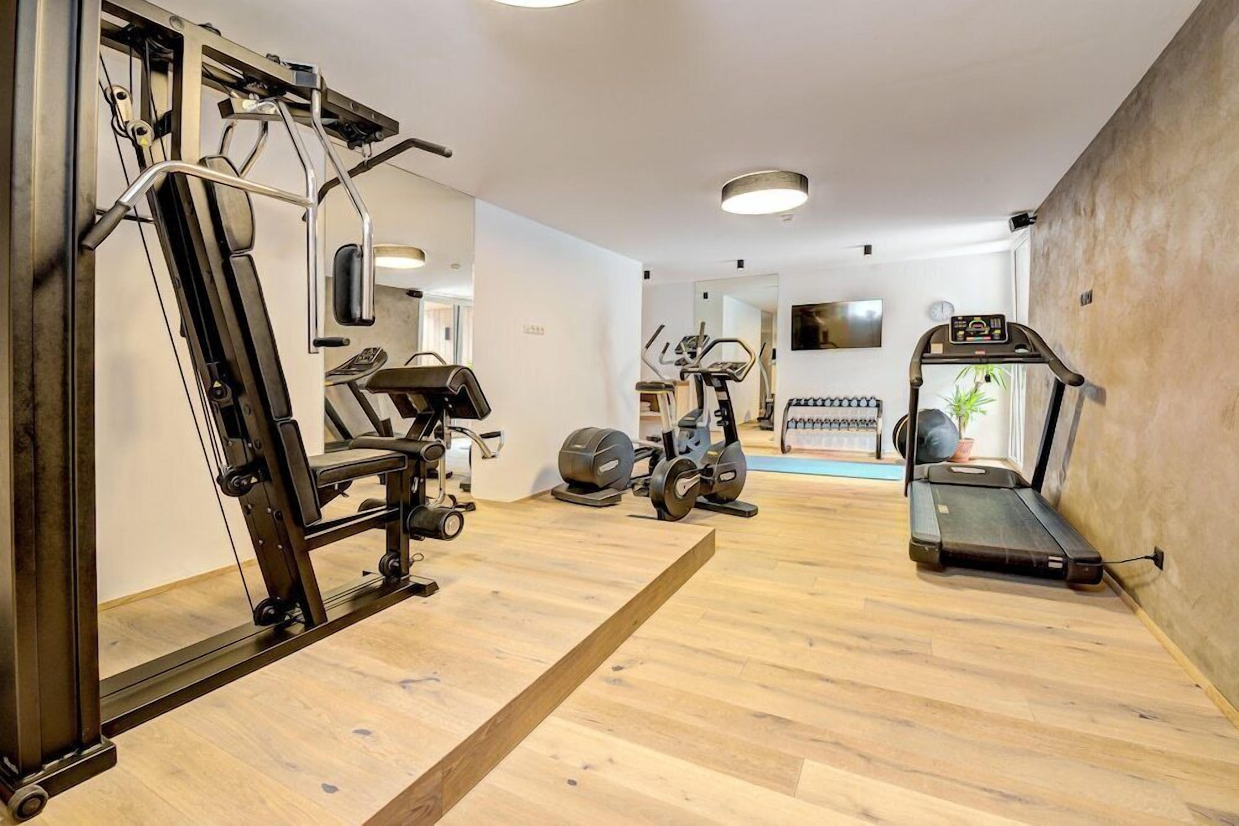 Un gimnasio con equipo de ejercicio, una cinta de correr y un espejo.