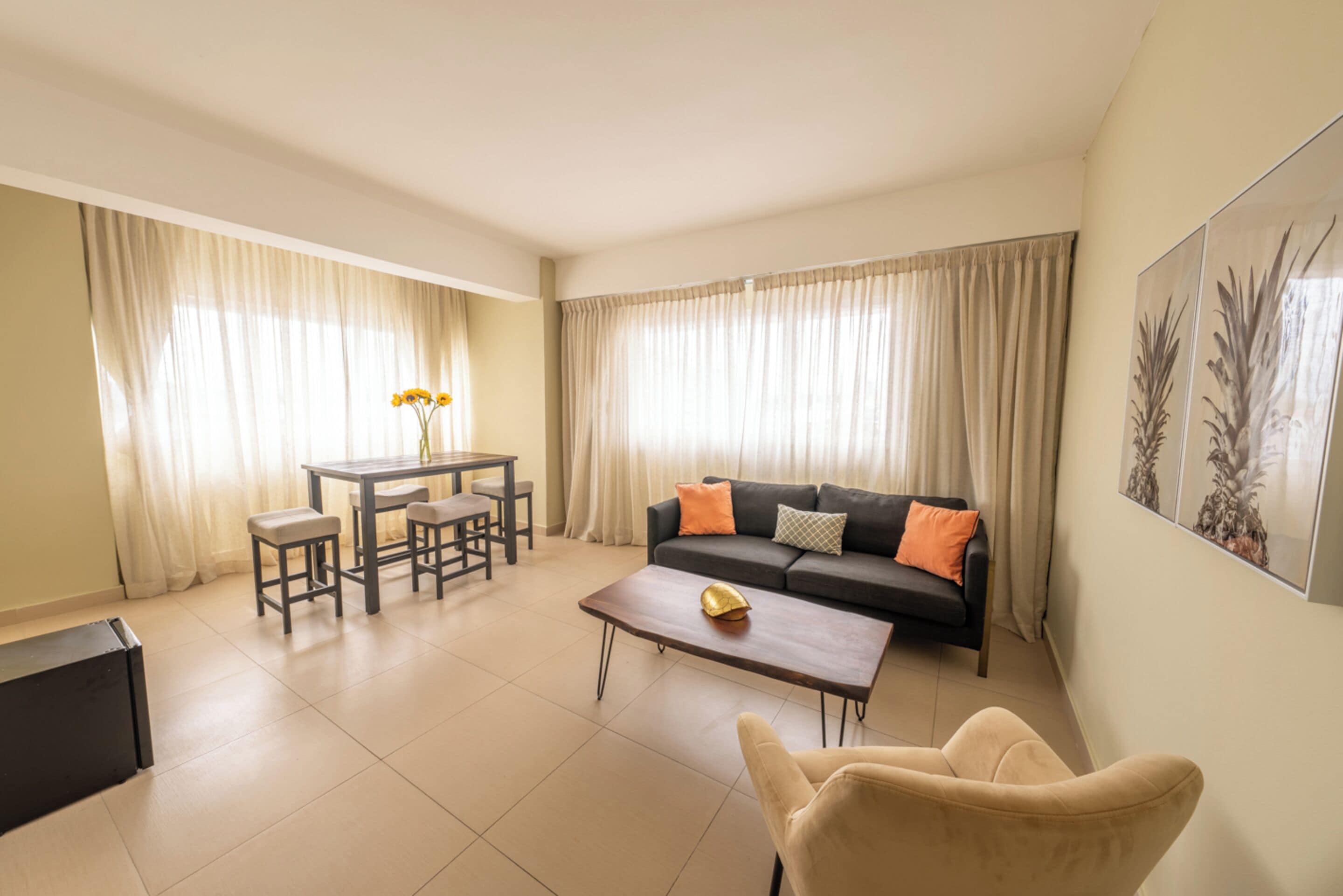 A living room with a sofa, coffee table, and a dining area with chairs and a table.