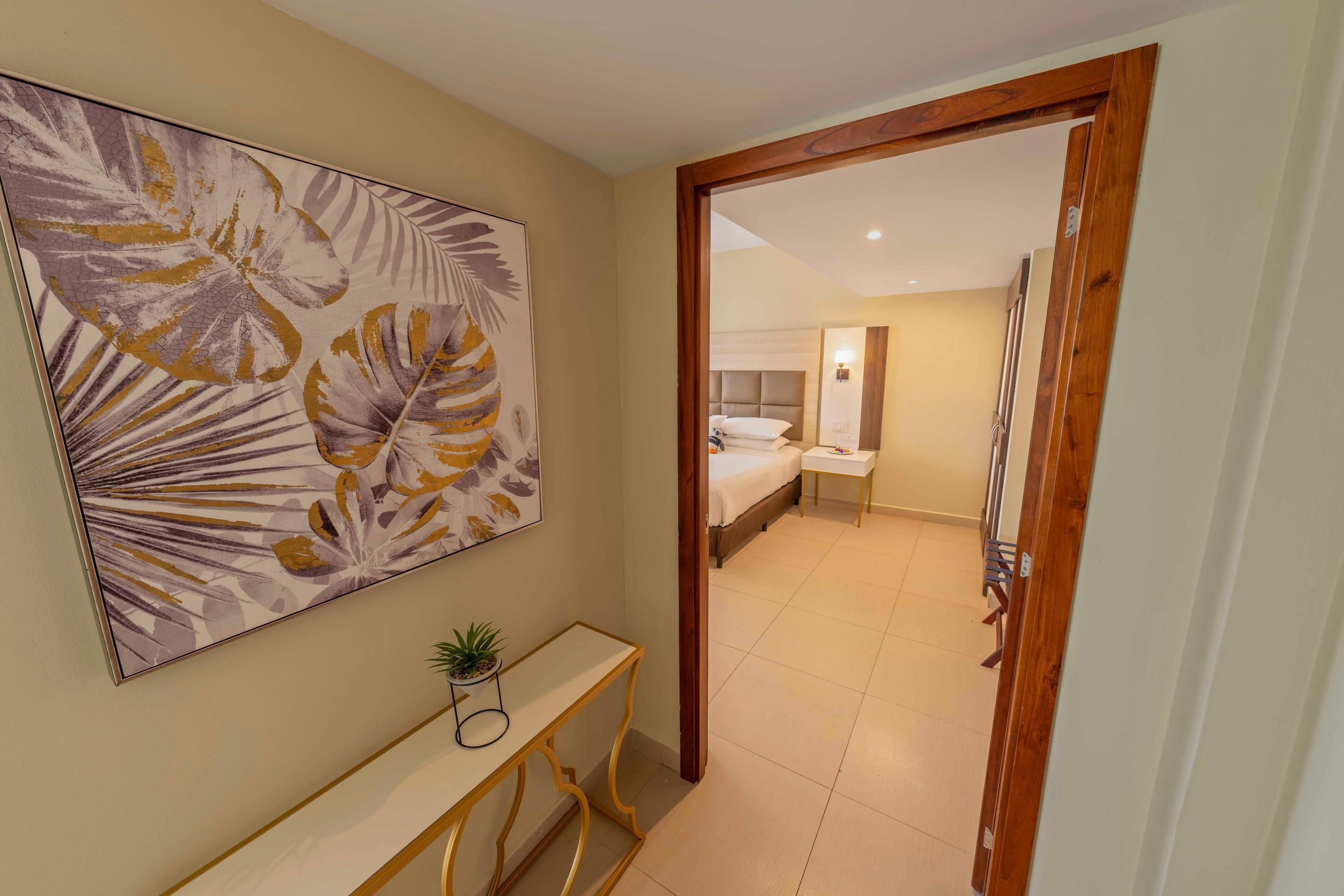 Une chambre d’hôtel avec un lit, une table de chevet et un grand tableau abstrait accroché au mur.