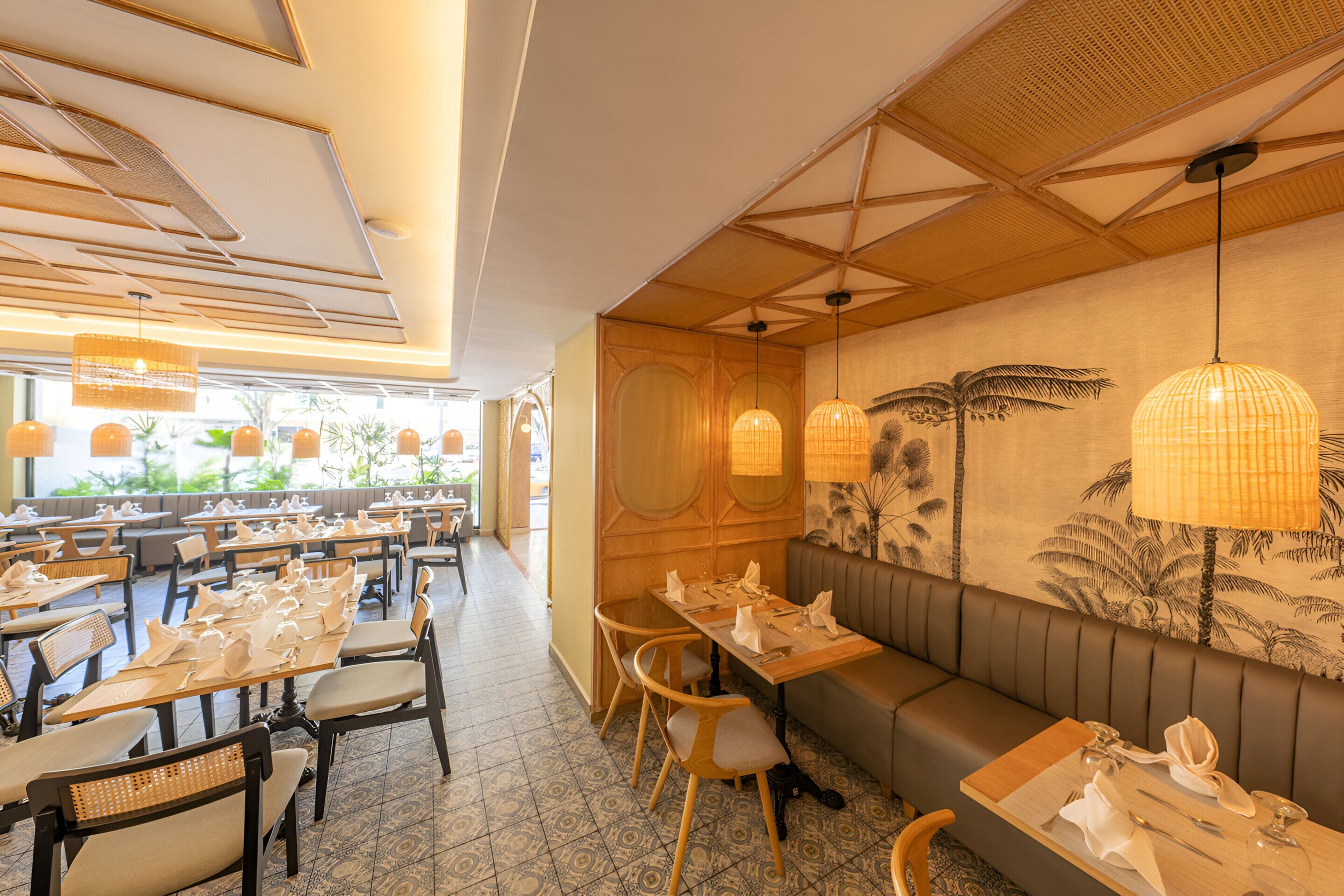 A restaurant with wooden tables, cushioned chairs, and a wall mural.