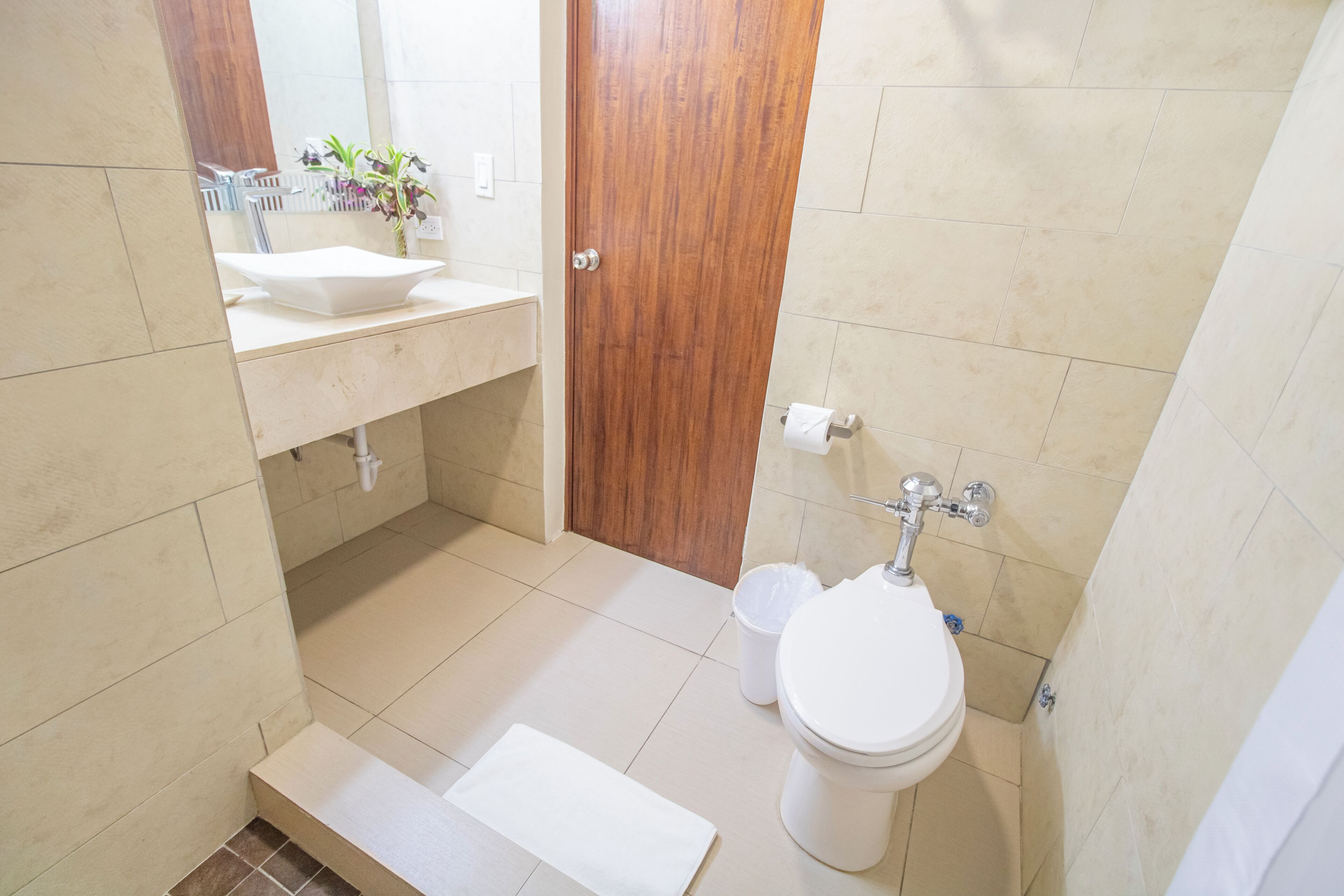 Un baño con lavamanos, inodoro y zona de ducha.
