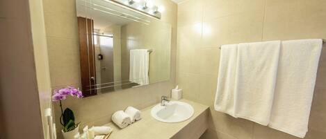 A bathroom with a sink, mirror, and two towels hanging on the wall.