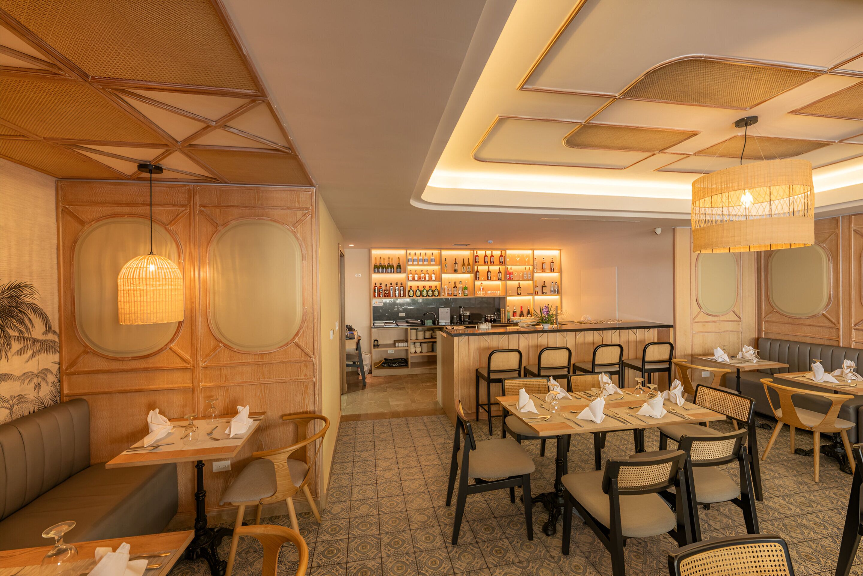 Un restaurante con zona de bar, paneles de madera y suelo estampado.